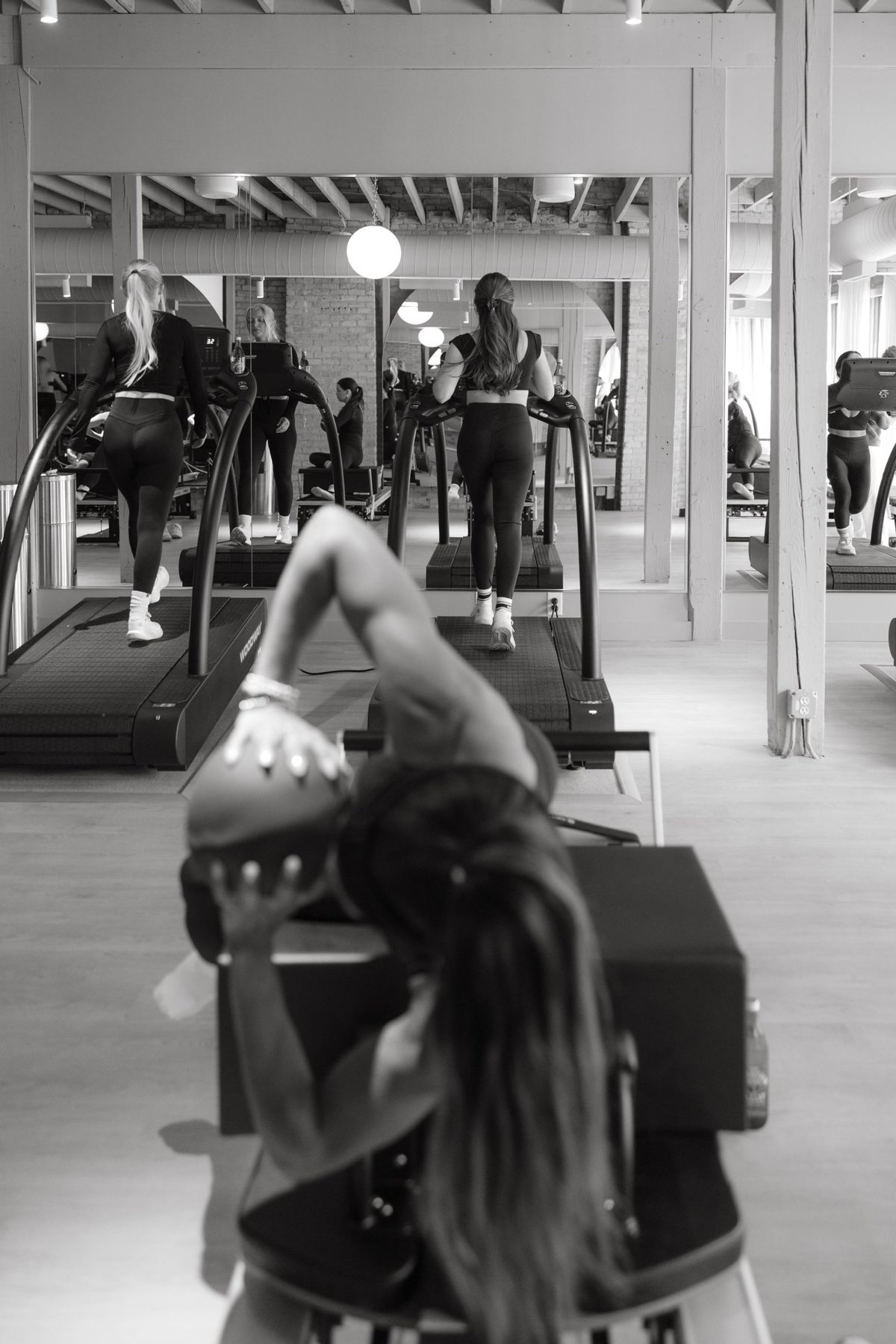A black-and-white editorial training moment inside a Rêve studio, the standard being taught, not assumed.